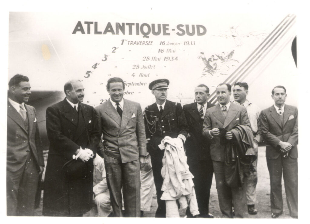 Au retour de la 8e traversée du Couzinet 71 "Arc-en-ciel", l'équipage est reçu au Bourget par le ministre d'Air et le général denain qui remet à Mermoz les insignes de commandeur de la légion d'honneur. de gauche à droite : Henri Guillaumet, Général Denain, Mermoz, Colonel Davet, Collenot, Gimié, Cavailles, Clavere 1934 Le Bourget